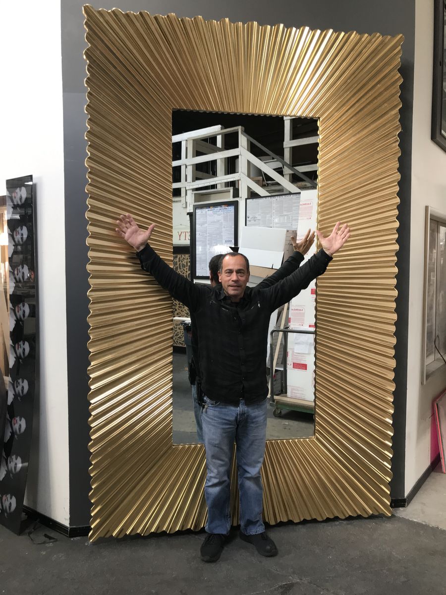 Ami Chen with a hand-carved, gold-leafed sunburst mirror in the Heart To Art studio
