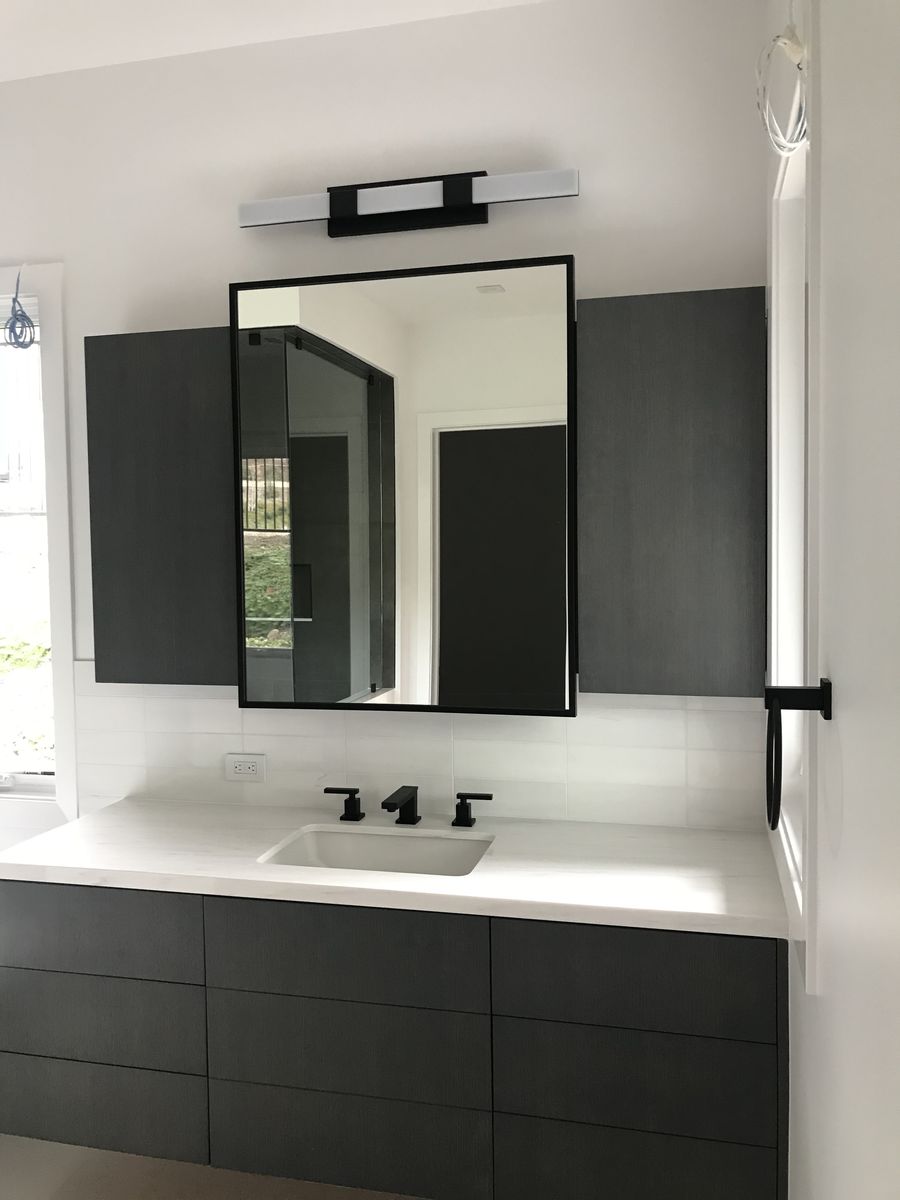 Modern black-framed mirror above a vanity